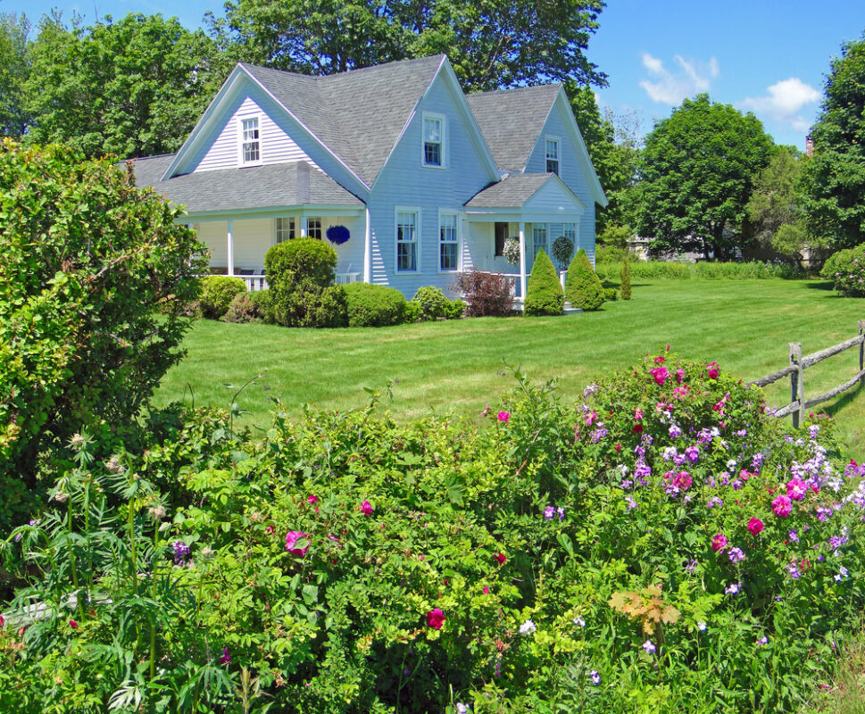 Integrated stone patio and layered planting design by Land Design Associates in Cohasset, Massachusetts