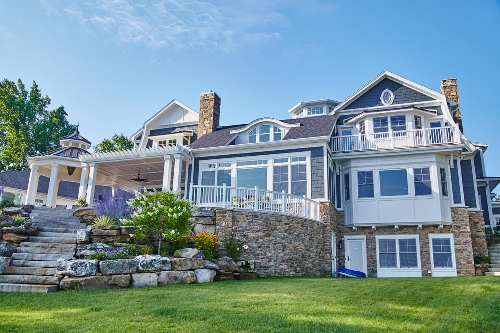 Luxury coastal home with stone retaining walls and landscaped hillside in Cohasset, Massachusetts