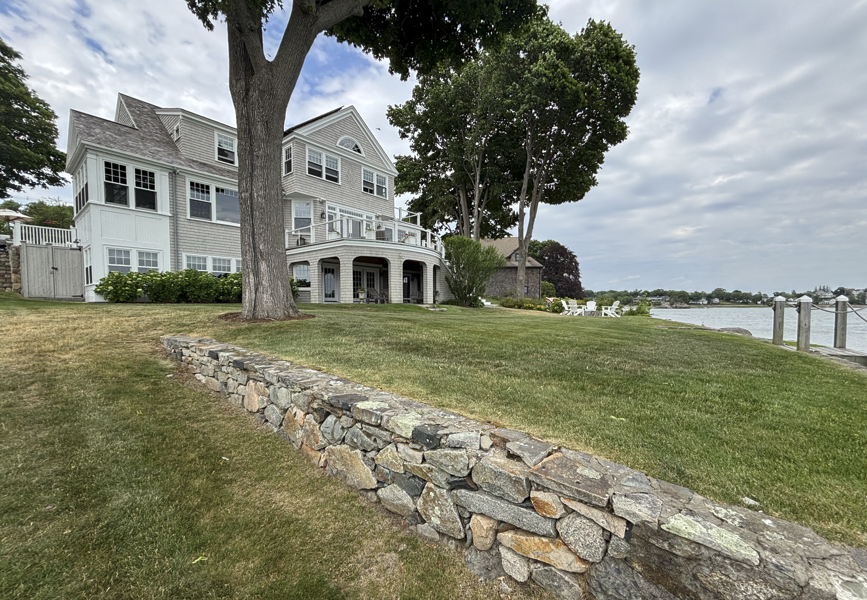 Dormant brown lawn in summer on a South Shore Massachusetts property next to green irrigated turf