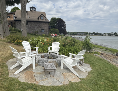Natural stone patio with outdoor fireplace, seating area and landscape lighting at a South Shore Massachusetts residence
