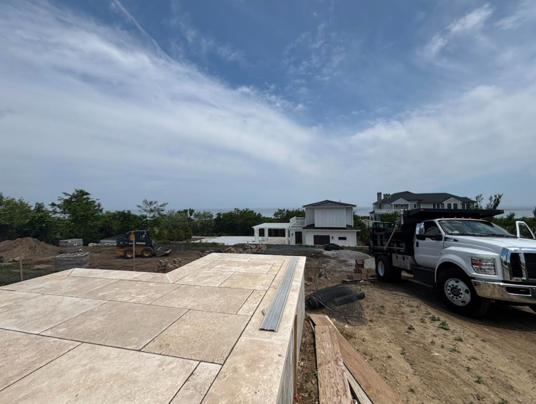 Contractor preparing the base for a paver patio installation in Massachusetts to ensure long-term longevity.