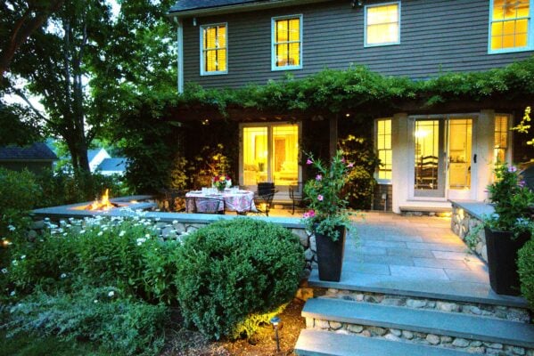 Landscape designer reviewing a site plan with homeowners during an initial consultation on a Massachusetts property