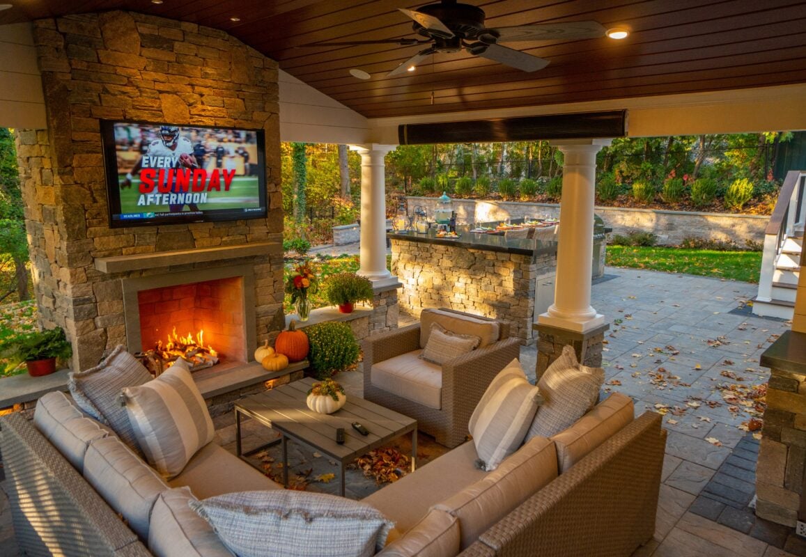 Luxury outdoor living space with kitchen, lounge, and lighting design in New England