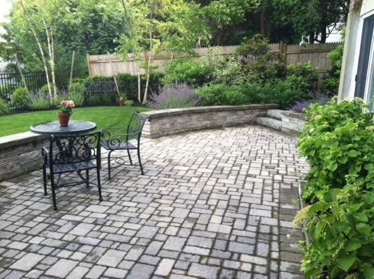 Cross-section of permeable paver driveway showing open-graded stone base for stormwater infiltration, used to meet Massachusetts impervious surface limits