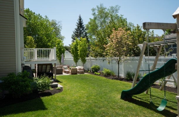 Solid mass-loaded fence at property line built to reduce traffic and neighbor noise, meeting Massachusetts height requirements