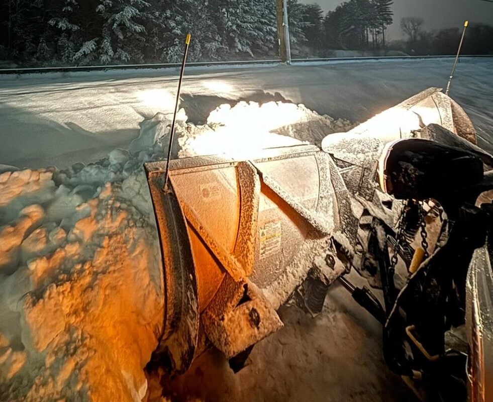 Property manager hiring a commercial snow removal contractor, meeting a Land Design Associates crew lead beside a plow truck in Walpole MA