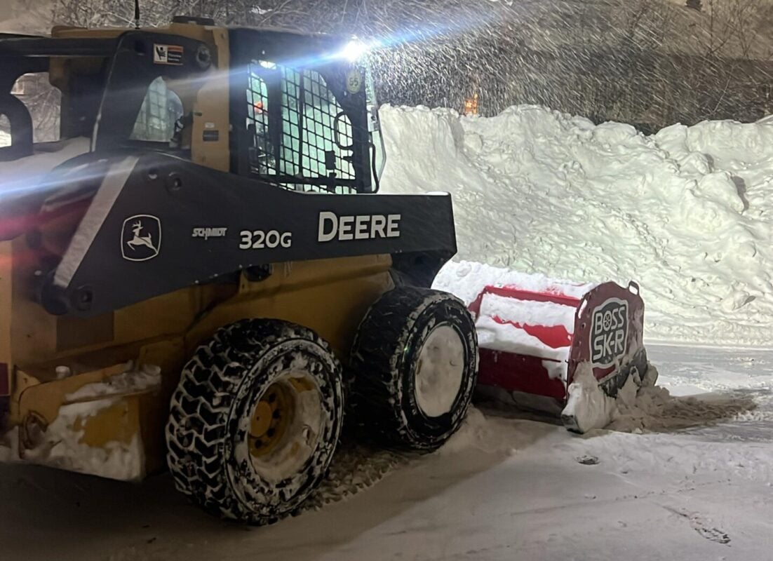 Land Design Associates plow truck clearing a commercial lot during a storm, for property managers switching snow removal contractors in Walpole MA