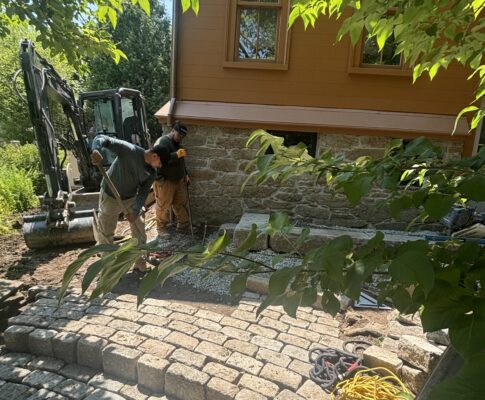 Bluestone patio with fire pit and landscape lighting built by Land Design Associates, one of the best landscape design-build companies in Massachusetts