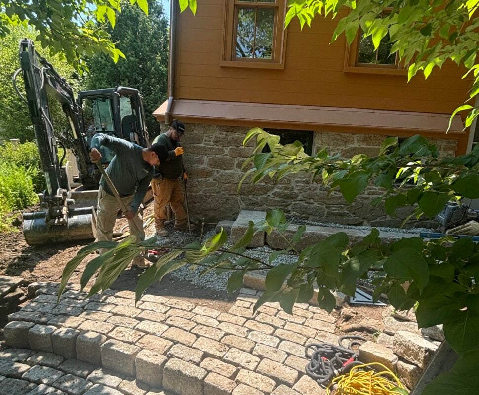 Bluestone patio with fire pit and landscape lighting built by Land Design Associates, one of the best landscape design-build companies in Massachusetts